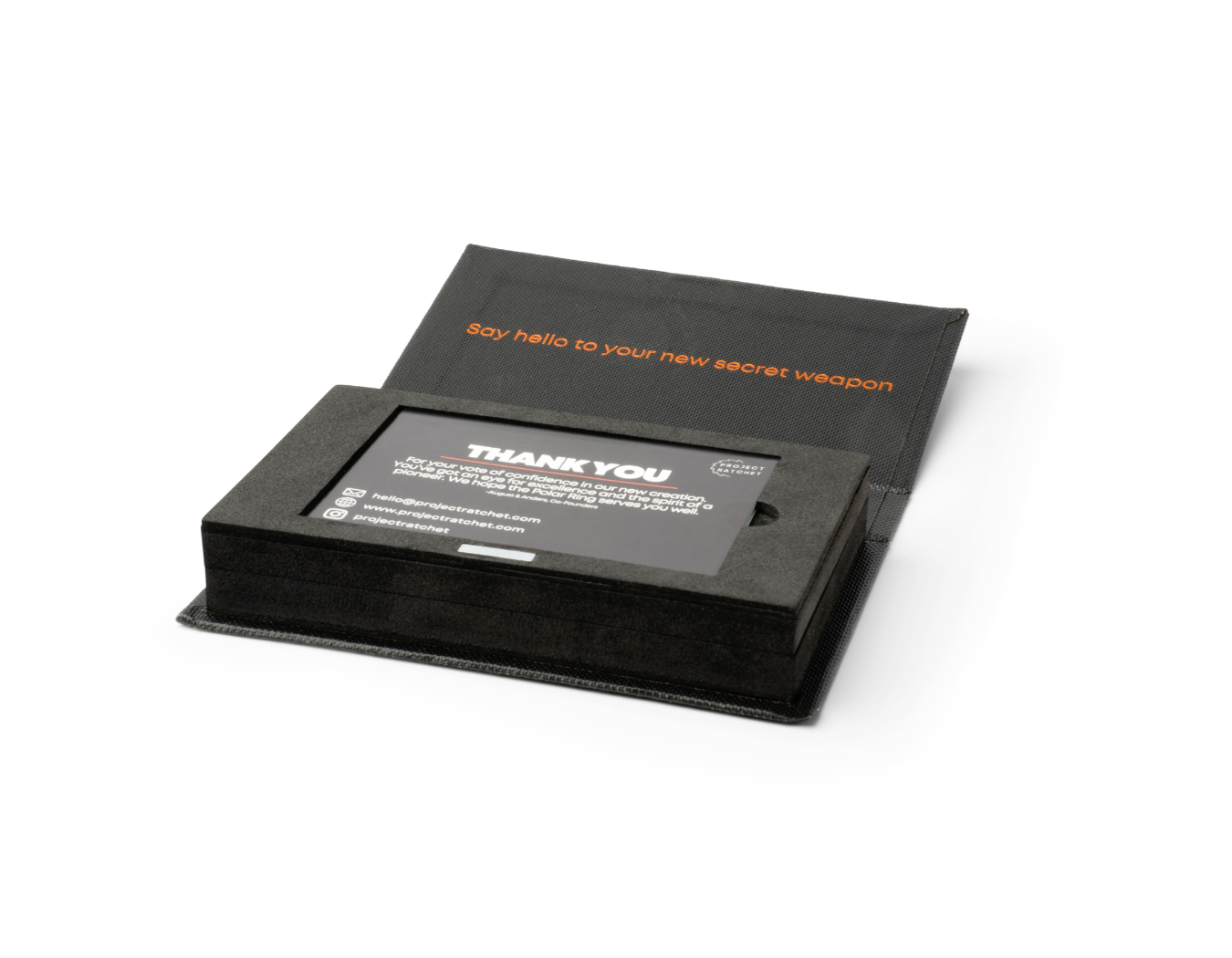 An open Project Ratchet ring box with certificate of authenticity card laying in it.