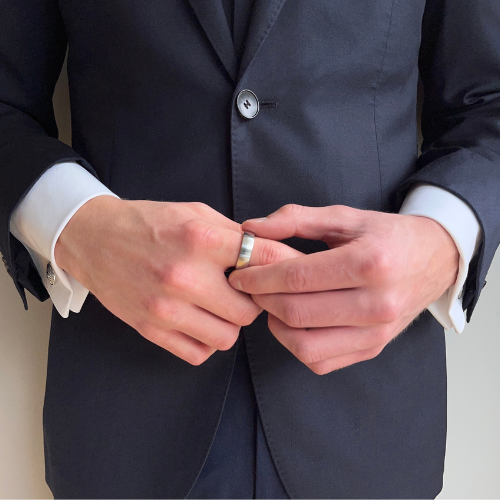 Male wearing suit holding the ratchet ring